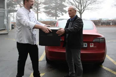 Übergabe der Essen an den Rotkreuz-Fahrer für die Auslieferung